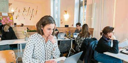 Offices, coworking spaces on the river island of Nantes (north-western France), Zero Newton building Offices for coworkers, coworking spaces: young woman working on a laptop with a smartphone close to her. (Photo by: Andia/Universal Images Group via Getty Images)