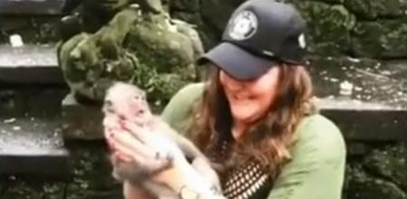 La mujer agarra al pequeño mono por el cuello antes de recibir el ataque
