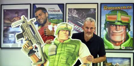 Xavier Carrillo, en las oficinas de Digital Legends, en Barcelona, agarrado a una imagen del juego 'Respawnables', y junto en los proyectos en los que ha creado o participado