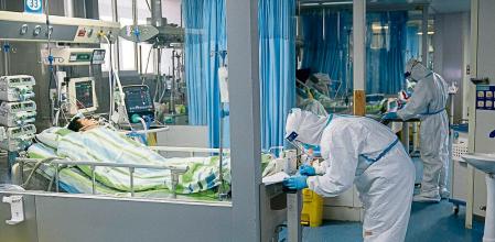 FILE - In this Jan. 24, 2020, file photo released by China's Xinhua News Agency, a medical worker attends to a patient in the intensive care unit at Zhongnan Hospital of Wuhan University in Wuhan in central China's Hubei Province. A 10-member team of international researchers from the World Health Organization hopes to find clues as to the origin of the coronavirus pandemic in the central Chinese city of Wuhan where the virus was first detected in late 2019. (Xiong Qi/Xinhua via AP, File)