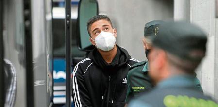 A CORUÑA, 05/08/2021.- Uno de los tres varones mayores de edad encarcelados como presuntos autores de la agresión que acabó con la vida de Samuel Luiz sale del edificio de los juzgados de A Coruña, conducido por agentes de la Guardia Civil al autobús que lo trasladará a la prisión de Teixeiro. EFE/ Cabalar
