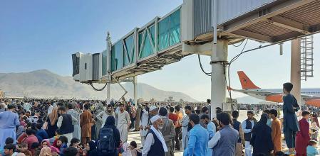 TOPSHOT - Afghans crowd at the tarmac of the Kabul airport on August 16, 2021, to flee the country as the Taliban were in control of Afghanistan after President Ashraf Ghani fled the country and conceded the insurgents had won the 20-year war. (Photo by - / AFP)