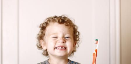 Cepillarle los dientes con un cepillo para bebé de cerdas suaves y agua