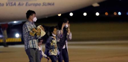 Una familia afgana atraviesa camina por las pistas de la base aérea de Torrejón de Ardoz