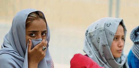 Recently evacuated Afghan women sit besides a baby at the Ramstein U.S. Air Base, Germany, Tuesday, Aug. 24, 2021.The largest American military community overseas housed thousands Afghan evacuees in an increasingly crowded tent city. (AP Photo/Matthias Schrader)