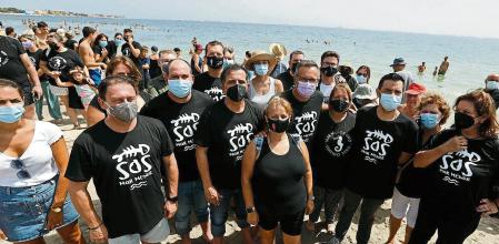 Miembros de la plataforma ILP Mar Menor posan en una fotografía durante una cadena humana convocada para guardar luto al Mar Menor, a 28 de agosto de 2021, en Murcia, (España). La plataforma ILP Mar Menor ha organizado esta cadena humana, que se extiende a lo largo de los 73 kilómetros que abarcan la laguna salada del Mar Menor. El acuífero del Mar Menor atraviesa una situación delicada en sus ecosistemas debido a las toneladas de nitratos y las decenas de millones de litros de agua dulce que llegan a esta laguna salada a través de las ramblas. 28 AGOSTO 2021;MURCIA;MAR MENOR;MAR Edu Botella / Europa Press 28/08/2021