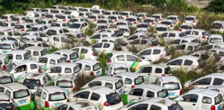 Cientos de coches eléctricos compartidos de la compañía Panda Auto se amontonan entre las hierbas en un solar remoto de la provincia de Chongqing&nbsp;