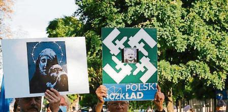 People hold signs during a protest against the state of emergency declared at the Polish border with Belarus, in front of the Parliament in Warsaw, Poland September 6, 2021. REUTERS/Kacper Pempel