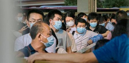 BEIJING, CHINA - AUGUST 27: Commuters wait in line for public buses as they leave work in the business district on August 27, 2021 in Beijing, China. China's Supreme People's Court ruled this week that its illegal for companies to subject employees to the practice known as 996