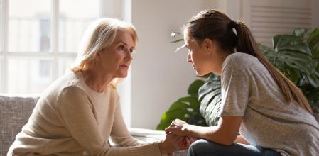 Grown up daughter holding hands of middle aged mother relatives female sitting look at each other having heart-to-heart talk, understanding support care and love of diverse generations women concept