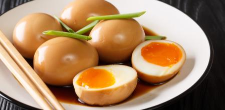 Huevos cocidos de nitamago en adobo de soja (Soft-boiled eggs of nitamago in soya marinade with green onions close-up in a plate on the table. horizontal
, ASCII, 110 components, 110 by