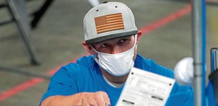 FILE - In this May 6, 2021, file photo, Maricopa County ballots cast in the 2020 general election are examined and recounted by contractors working for Florida-based company, Cyber Ninjas, at Veterans Memorial Coliseum in Phoenix. Cyber Ninjas, the inexperienced contractor hired to run a partisan review of the 2020 election on behalf of Republicans in the Arizona Senate, is scheduled to present its findings to top GOP lawmakers on Friday, Sept. 24, 2021. Election experts say the review, funded almost entirely by supporters of former President Donald Trump who have promoted false claims of fraud, was beset by problems and incompetence. (AP Photo/Matt York, Pool)