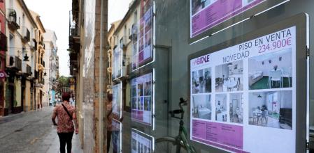 Una persona pasa ante el escaparate de una agencia inmobiliaria en València