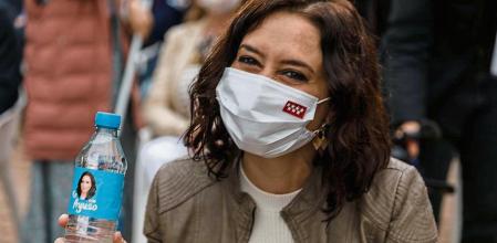 La presidenta de la Comunidad de Madrid y candidata a la reelección, Isabel Díaz Ayuso , junto al líder del PP, Pablo Casado bebiendo de una borella de agua con la cara de Ayuso, y al portavoz del Gobierno regional y consejero de Educación, Enrique Ossorio, durante un acto de campaña celebrado este sábado en Pozuelo de Alarcón.