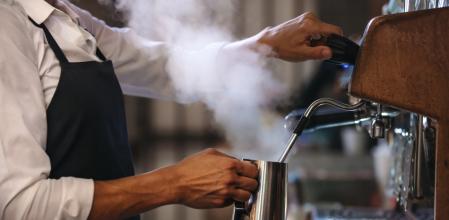 Un camarero preparando cafés