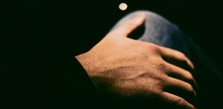 Man puts his hand on a woman's thigh by night - Fotografía de stock