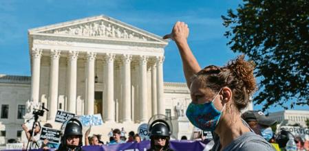 A demonstrator gestures toward pro-life activists holding signs during a Women's March outside the Supreme Court in Washington, D.C. U.S., on Saturday, Oct. 2, 2021. Women's March and more than 90 other organizations organized a national rally to protect women's reproductive rights ahead of the Supreme Court reconvening on October 4. Photographer: Shuran Huang/Bloomberg