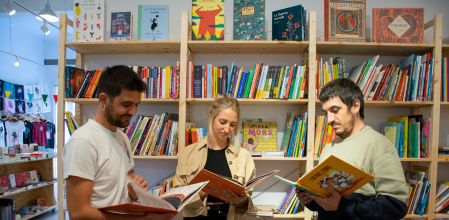 Los impulsores del proyecto 'Zoo Il·lustrat' hojean los libros de la colección.