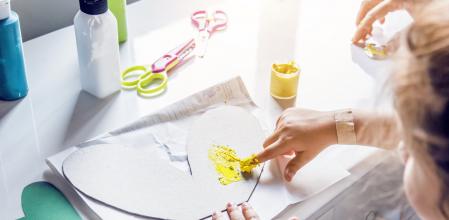 An unrecognizable little girl doing finger painting