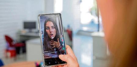 Una persona mira en su móvil el vídeo de una joven en la red musical Tik Tok, en Madrid (España), a 22 de septiembre de 2020. TikTok ha publicado este martes su tercer Informe de Transparencia, que recoge la actividad del primer semestre de 2020, en el que se eliminaron más de cien millones de vídeos por infringir las normas de la plataforma. 22 SEPTIEMBRE 2020;TECNOLOGIA;REDES SOCIALES;VÍDEOS;MÚSICA Europa Press / Europa Press 22/09/2020