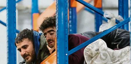 Migrants stay in the transport and logistics centre near the Bruzgi border point on the Belarusian-Polish border in the Grodno region on November 19, 2021. - Around 2,000 migrants who had been camped out in freezing conditions at Belarus's border with Poland spent the night in a logistics centre after their camp was cleared by border guards, state news agency Belta said on November 19. Thousands of migrants -- mainly Iraqi Kurds -- have spent months trying to get into the EU from Belarus in a crisis the West says Belarusian President Alexander Lukashenko engineered as retribution for sanctions imposed against his regime. Minsk has denied the charges. (Photo by Maxim GUCHEK / BELTA / AFP) / Belarus OUT