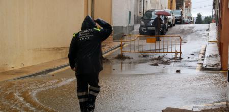 Un vigilante municipal de Santa Bàrbara caminando por una calle llena de agua, ese martes