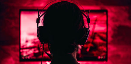 Una joven frente a una pantalla, jugando a un videojuego