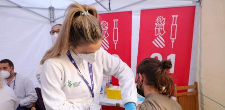 Una sanitaria administra una dosis contra la Covid-19 en el punto móvil de la plaza Manises de València