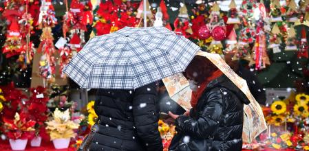 Dos personas pasean en un mercado navideño en Milán