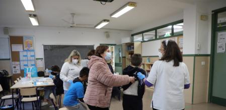 Una madre acompaña a su hijo en la vacunación del CEIP Antonio Machado de València