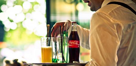 Un camarero sirve bebidas a los clientes