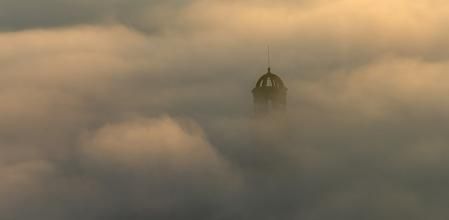 Campanario de la iglesia de Sant Hipòlit de Voltregà entre la niebla.