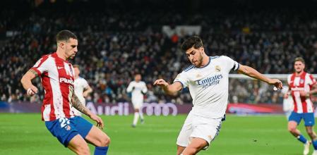 MADRID, SPAIN - DECEMBER 12: Marco Asensio of Real Madrid CF is challenged by Mario Hermoso of Atletico de Madrid during the La Liga Santander match between Real Madrid CF and Club Atletico de Madrid at Estadio Santiago Bernabeu on December 12, 2021 in Madrid, Spain. (Photo by Denis Doyle/Getty Images)