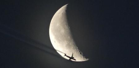 La luna menguante atravesada por un avión, vista desde Gavà.