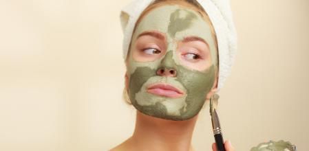 Rutina de cuidado de piel, mujer aplicándose una mascarilla facial