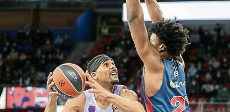 GRAF3548. VITORIA, 30/12/2021.- El pívot estadounidense del Bitci Baskonia Steve Enoch (d), defiende al estadounidense de pasaporte ugandés Brandon Davies, del FC Barcelona, en una jugada del partido correspondiente a la jornada 18 de la fase regular de la Euroliga de baloncesto, disputado este jueves en la cancha del pabellón Fernando Buesa de Vitoria. EFE/David Aguilar