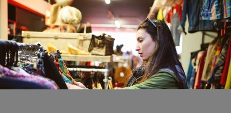 Mujer comprando en una tienda de ropa de segunda mano.