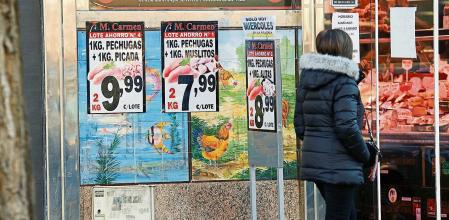 MADRID, 15/12/2021.- Una mujer camina frente a una charcutería en Madrid, este miércoles. La inflación interanual en España se situó en el 5,5 % al cierre de noviembre, una décima por encima de la anotada en octubre, debido sobre todo al encarecimiento de la alimentación frente al mes anterior, así como al aumento de los precios de la energía. EFE/ Chema Moya