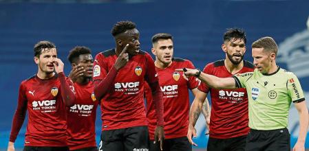 MADRID, 08/01/2022.- Los jugadores del Valencia protestan al colegiado Hernández Hernández el penalti pitado a favor del Real Madrid durante el encuentro correspondiente a la jornada 20 de primera división que disputan hoy sábado en el estadio Santiago Bernabéu, en Madrid. EFE / Mariscal.