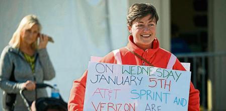 In this January 3, 2022 photo, a woman holds a sign about the impending launch of 5G services by AT&T and Verizon, at a rally against Covid-19 vaccine mandates in Huntington Beach, California. - A Verizon spokesperson said the company would begin 5G service on Wednesday for some 90 million Americans, but the firm has
