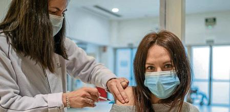 GRAF2296. OURENSE, 19/01/2022.- Una mujer recibe la vacuna contra el coronavirus en el recinto ferial de Expourense en Ourense este miércoles durante la campaña de vacunación de la tercera dosis en Galicia al grupo de edad de entre 30 y 39 años. Actualmente, Galicia suma más de 6.500 contagios y prolonga el pico de la ola. EFE/Brais Lorenzo
