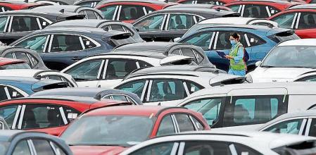 GRAFCVA4987. ALMUSSAFES (VALENCIA), 12/05/2020.- Una trabajadora de Ford camina, este martes, entre automóviles aparcados en el exterior de la planta en Almussafes (Valencia), y listos para ser enviados a los concesionarios. Los representantes de la dirección y de los trabajadores retoman este martes la negociación de un Expediente de Regulación de Empleo (ERE) de 410 despidos, por la bajada de la producción en 100 unidades diarias. EFE/Kai Försterling