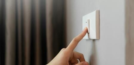 Una mujer apaga la luz en una vivienda