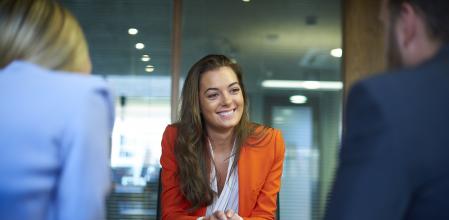 Una mujer sonríe en una entrevista de trabajo