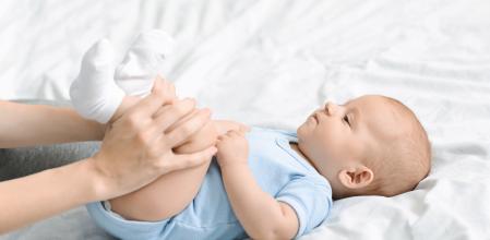 Constipation in babies. Mom doing gymnastics with her newborn child to relieve gas, panorama