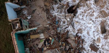 Vista aérea de un hombre recogiendo escombros de una casa que se derrumbó en Atafona (Brasil).