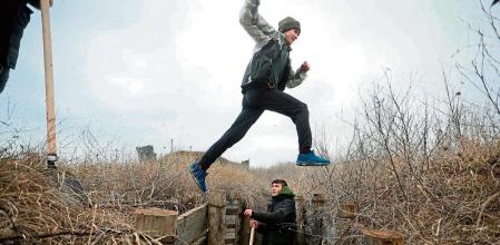 Ukrainian teenagers dig trenches for soldiers serving on their country's eastern front and facing off with Russian-backed separatists, near the eastern Ukraine village of Chervone, Mariupol region, on February 11, 2022. (Photo by Aleksey Filippov / AFP)