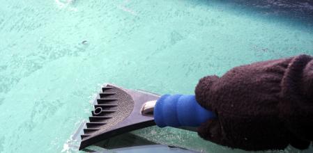 Rascador de plástico sobre un parabrisas helado