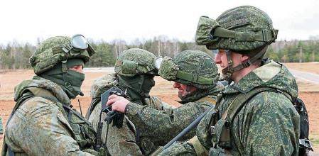 This handout video grab taken and released by the Ministry of Defence Republic of Belarus on February 19, 2022, shows Russian (L) and Belarus (R) soldiers shaking hands during joint exercises of the armed forces of Russia and Belarus as part of an inspection of the Union State's Response Force, at a firing range near Brest. (Photo by Handout / MINISTRY OF DEFENCE REPUBLIC OF BELARUS / AFP) / RESTRICTED TO EDITORIAL USE - MANDATORY CREDIT 