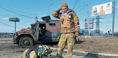 TOPSHOT - Ukrainian Territorial Defence fighters test the automatic grenade launcher taken from a destroyed Russian infantry mobility vehicle GAZ Tigr after the fight in Kharkiv on February 27, 2022. - Ukrainian forces secured full control of Kharkiv on February 27, 2022 following street fighting with Russian troops in the country's second biggest city, the local governor said. (Photo by Sergey BOBOK / AFP)